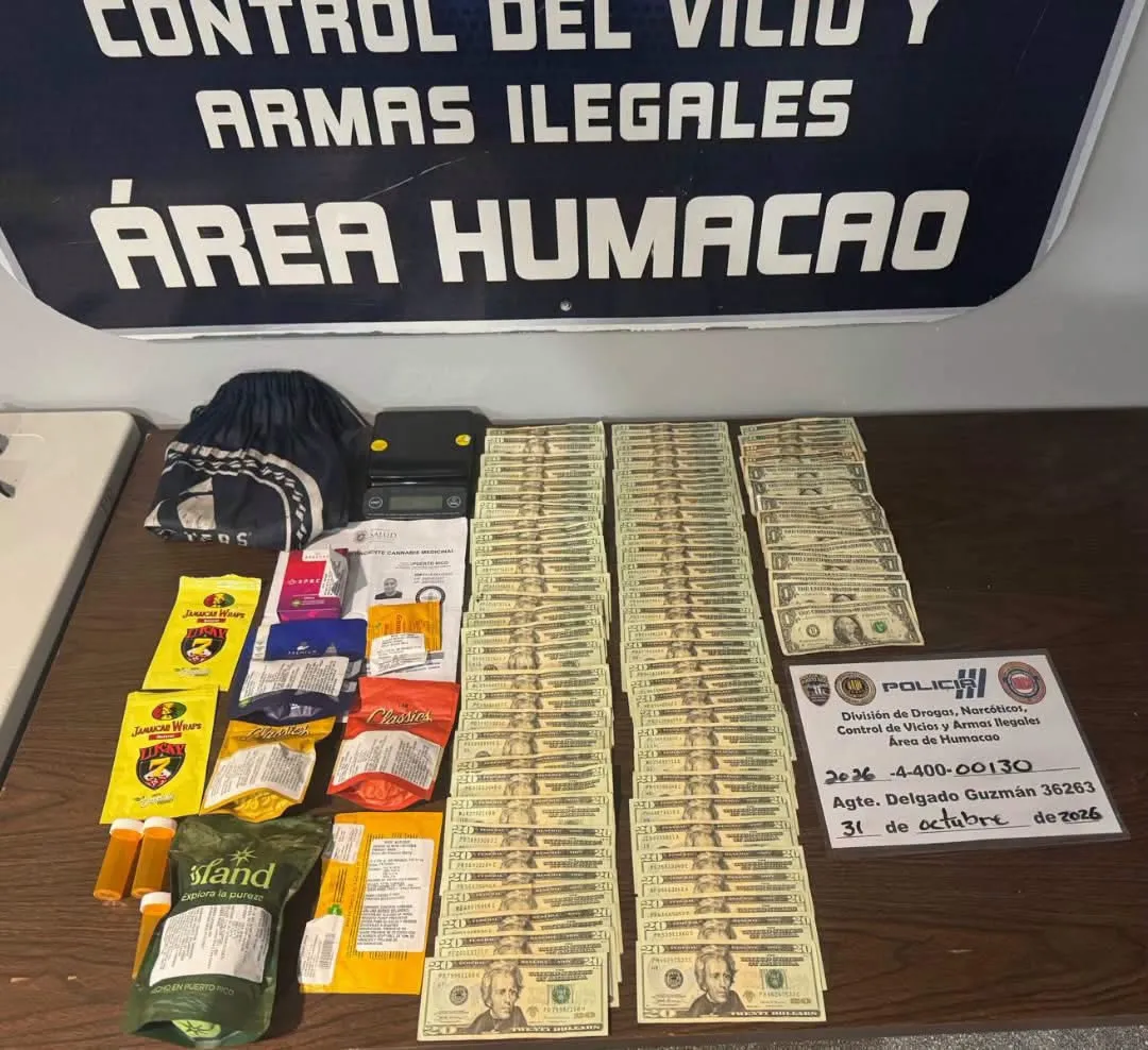 Mesa de evidencia de la Policía de Puerto Rico en Humacao con filas de billetes de veinte y de un dólar, bolsas de marihuana, una balanza digital y la tarjeta del caso de la División de Drogas, Narcóticos, Control de Vicios y Armas Ilegales del área de Humacao.