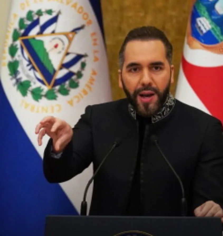 Fotografía del presidente de El Salvador, Nayib Bukele, hablando desde un podio con las banderas de su país detrás.