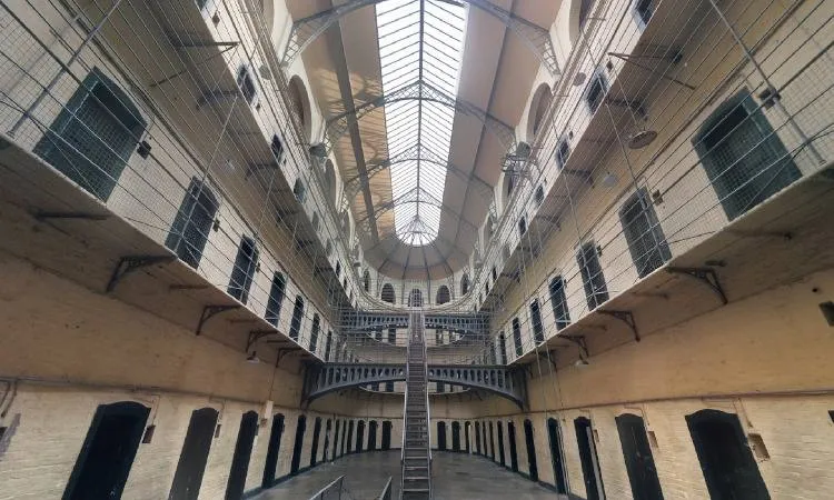 Interior de una institución penal con filas de celdas en varios niveles