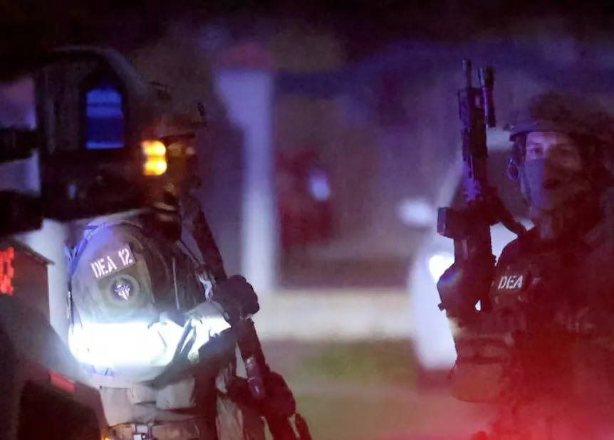 Agentes tácticos de la DEA, con rifles y linternas, durante el operativo de madrugada.