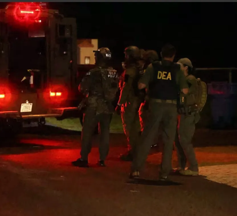 Agentes de la DEA se agrupan junto a un vehículo oficial en medio del operativo nocturno.