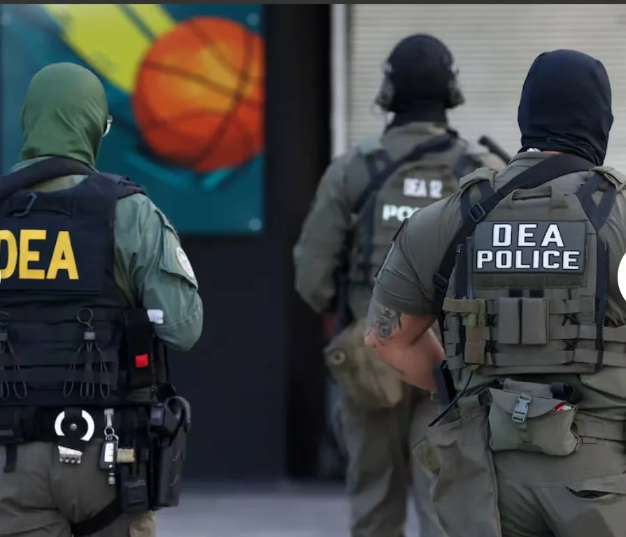 Agentes federales, de espaldas, en el área del operativo; al fondo, el mural de una cancha de baloncesto.
