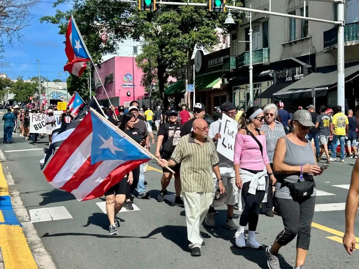 Manifestantes marchan con la bandera de Puerto Rico al frente contra LUMA Energy en Santurce
