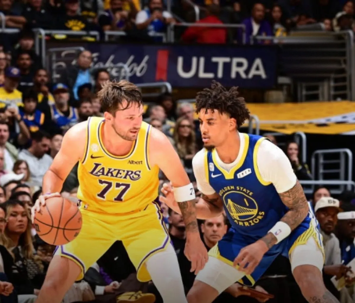 Fotografía de Luka Dončić, de los Lakers, con el balón ante la defensa de Yaxel Lendeborg, de los Golden State Warriors, durante el primer partido de la temporada en Los Ángeles