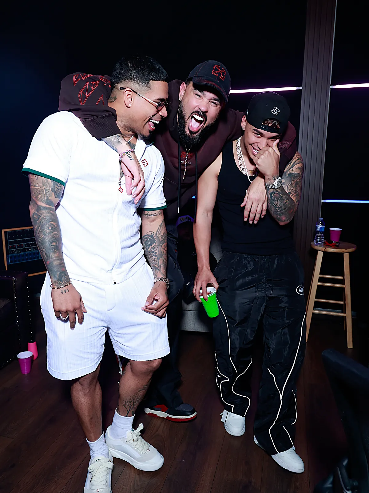 Michael Flores, Raphy Pina y Jlexis ríen juntos dentro de un estudio de grabación en Puerto Rico