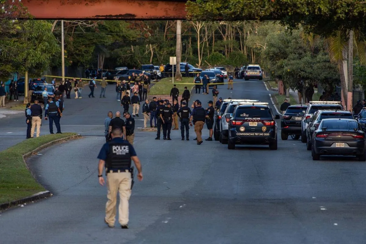 Una calle ancha acordonada durante el día con numerosos agentes y patrullas de la Policía